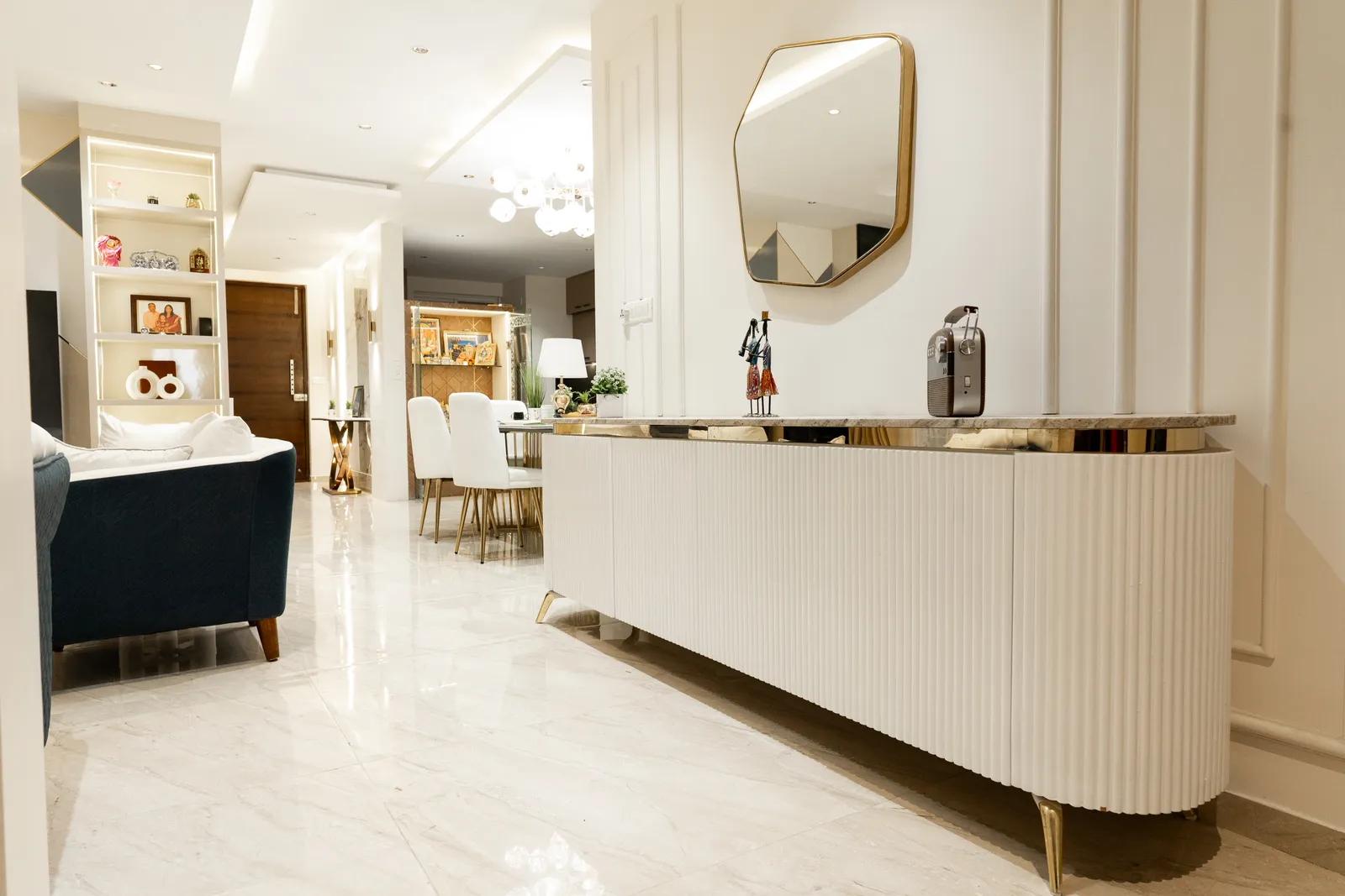 Living area with curved fluted console and round gold mirror — Arna's Home
